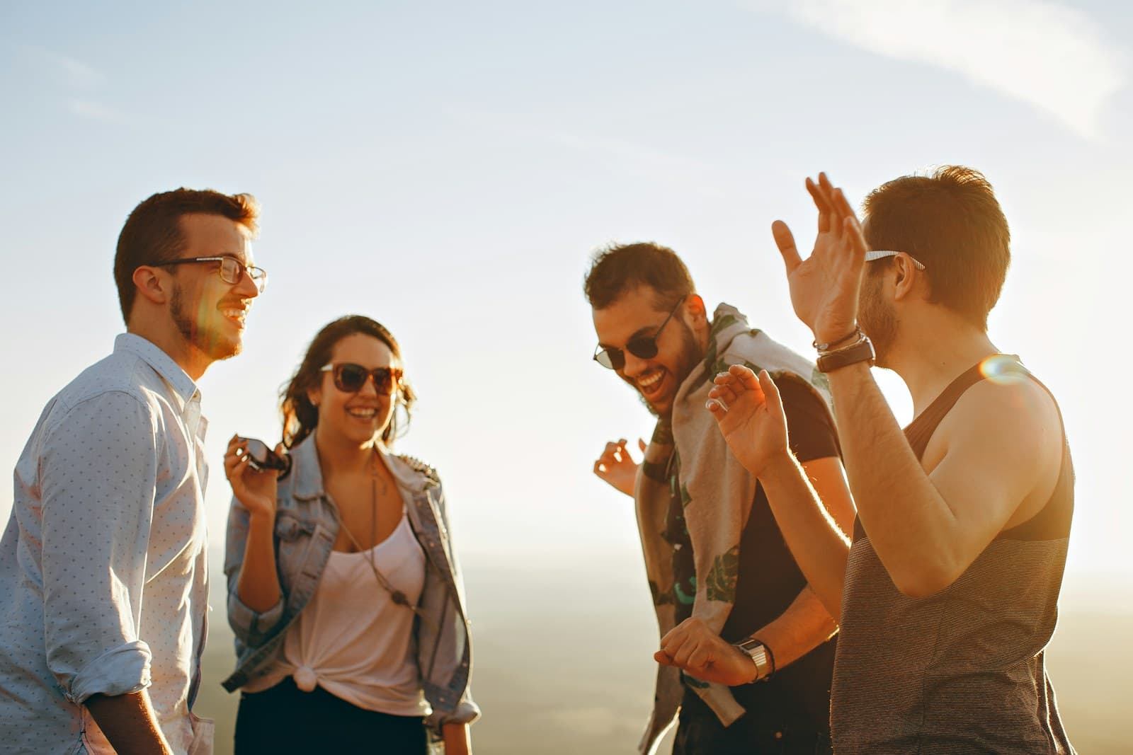 Four young friends laughing together outdoors